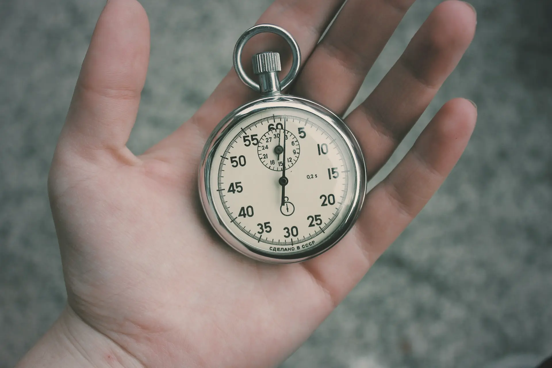 person holding white and silver-colored pocket watch